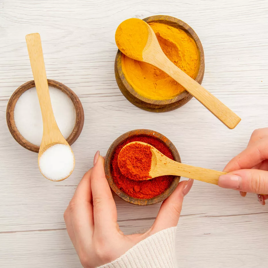 Épices en pots avec cuillères en bois